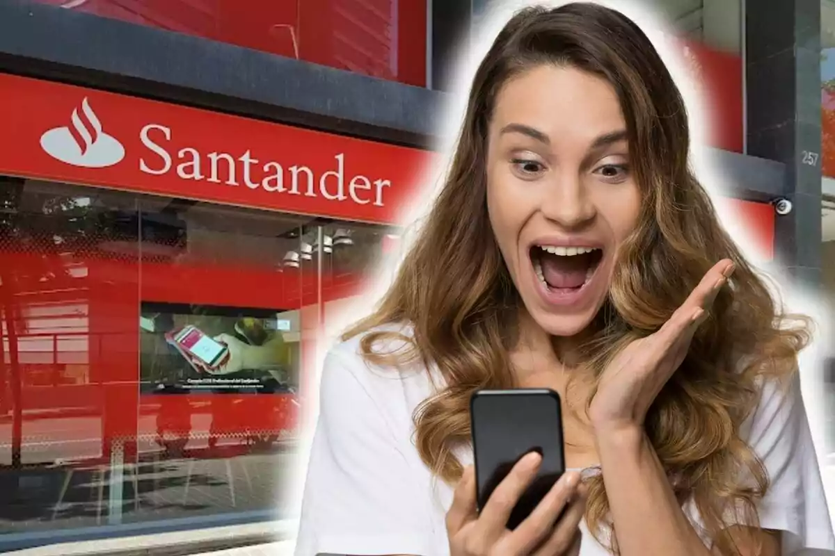 Dona emocionada mirant el telèfon davant d'una sucursal del Banco Santander.