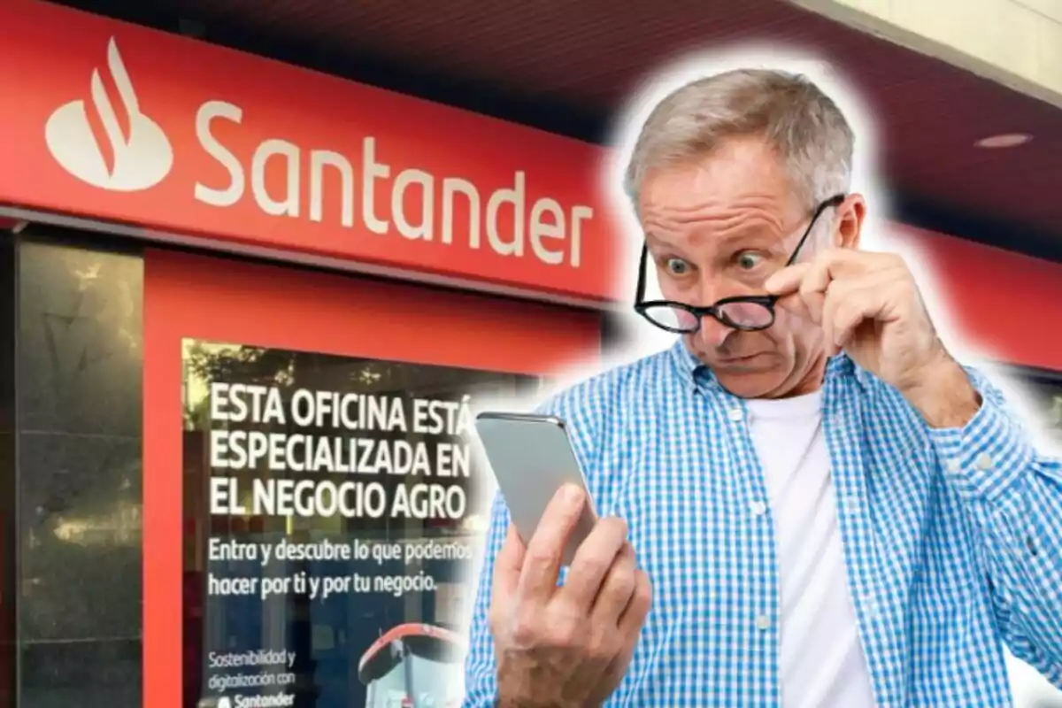 Home gran mirant el seu telèfon davant d'una sucursal del banc Santander especialitzada en el negoci agro.