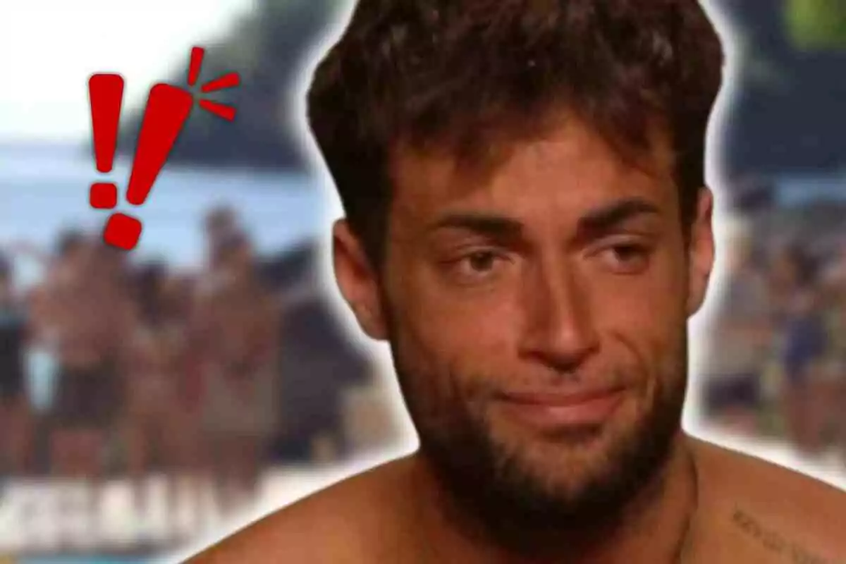 Montoya amb expressió de resignació o tristesa en primer pla amb un fons de platja desenfocat i signes d’exclamació vermells a l’esquerra
