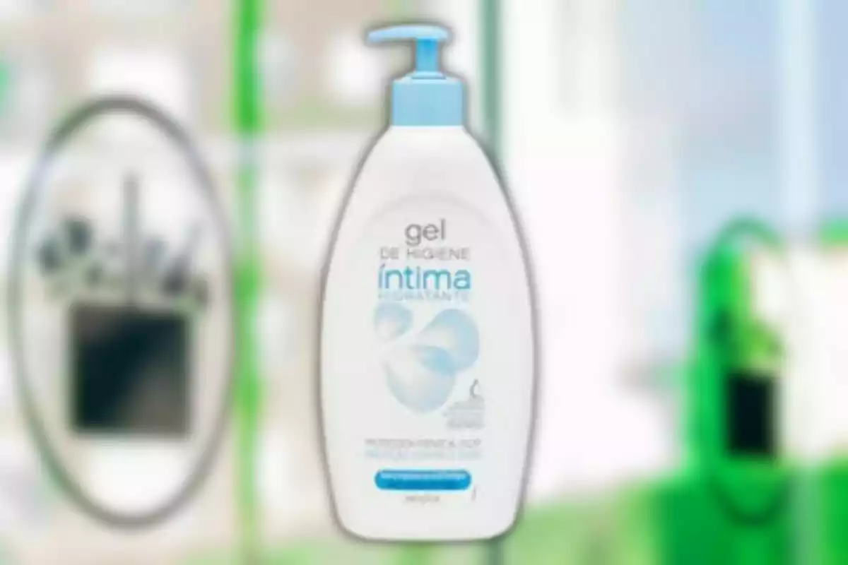 Ampolla de gel d'higiene íntima amb dispensador blau sobre un fons desenfocat. Ampolla de gel d'higiene íntima amb dispensador blau sobre un fons desenfocat.