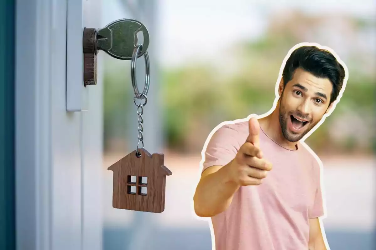 Un home somrient assenyalant endavant amb una clau en un pany i un clauer en forma de casa.