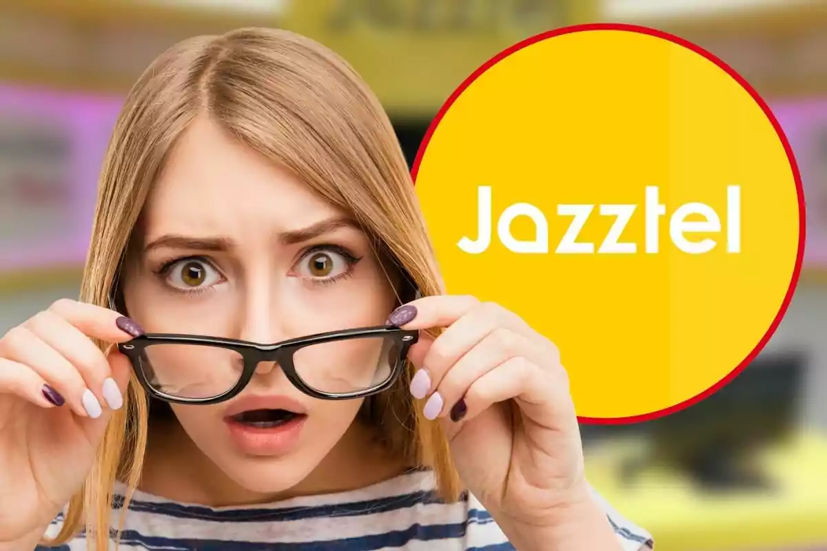 Dona sorpresa sostenint les ulleres davant d'un logotip groc de Jazztel.