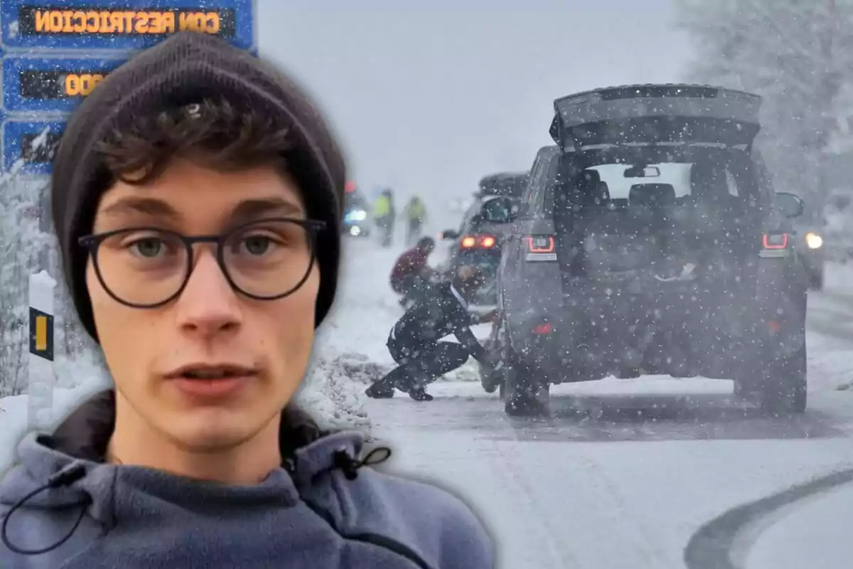 Un jove amb ulleres i gorra apareix en primer pla mentre al fons s?observa una carretera nevada amb persones col·locant cadenes a les llantes d?un vehicle.