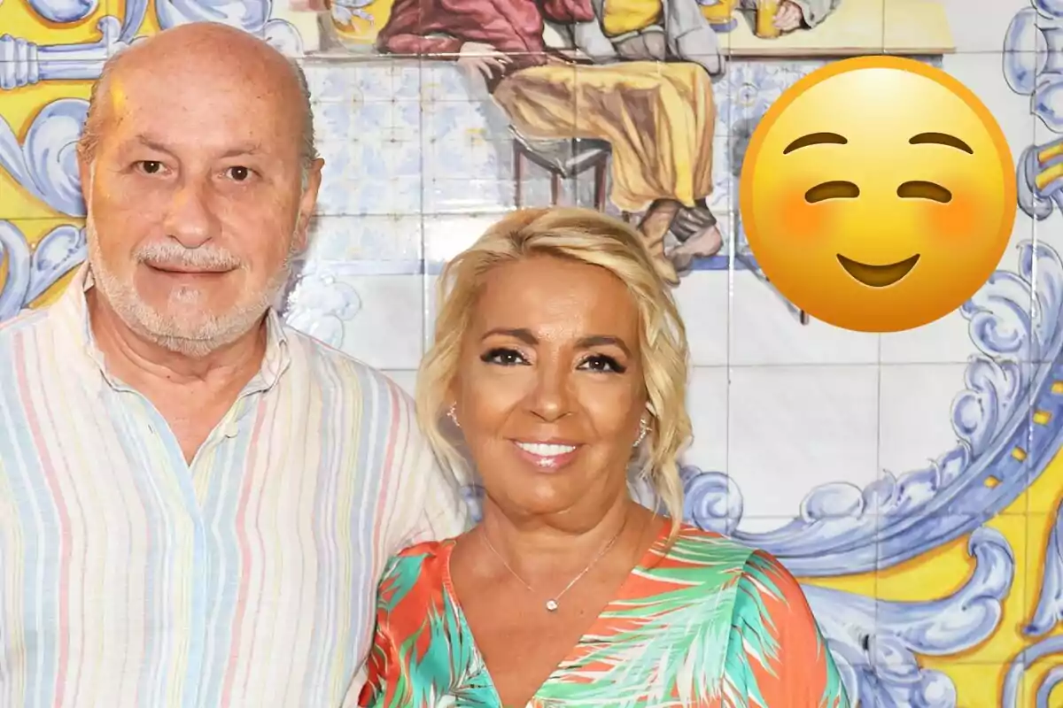 José Carlos Bernal i Carmen Borrego somrients posen davant d’un mural colorit amb un emoji de cara somrient gran a la dreta.