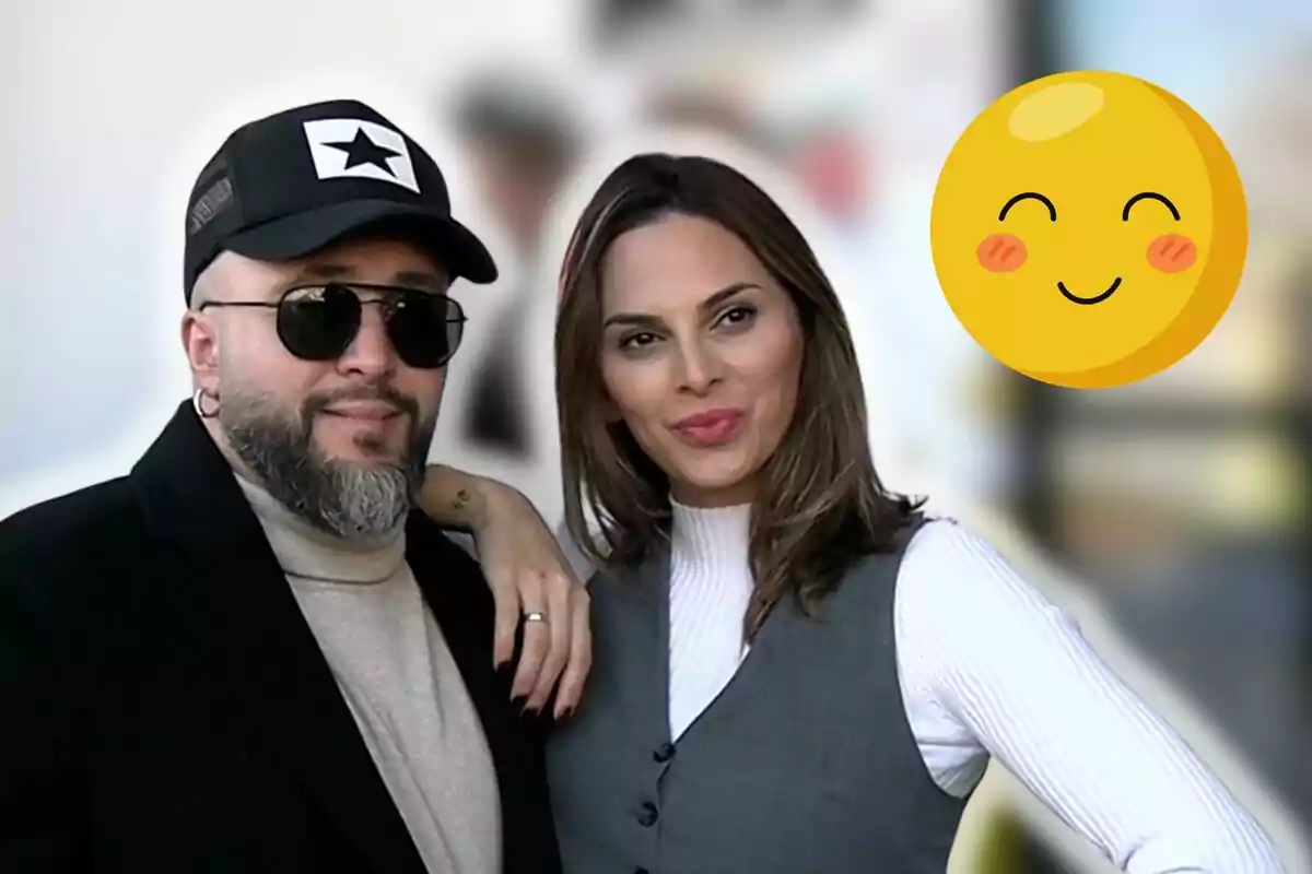 Kiko Rivera i Irene Rosales posant juntes, una porta ulleres de sol i gorra, mentre que l'altra somriu; hi ha un emoji somrient al cantó superior dret.