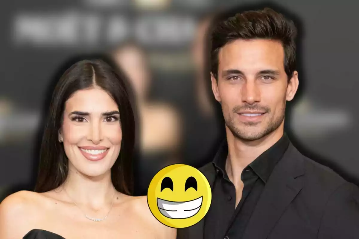 Lidia Torrent i Jaime Astrain posen junts somrient amb un emoji de cara feliç gran al centre de la imatge i el fons desenfocat