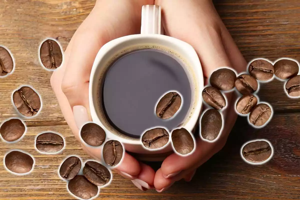 Muntatge amb unes mans subjectant una tassa plena de cafè i diversos grans de cafè