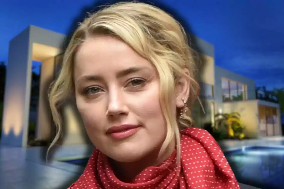 Amber Heard with a red scarf in front of a modern house lit up at night.