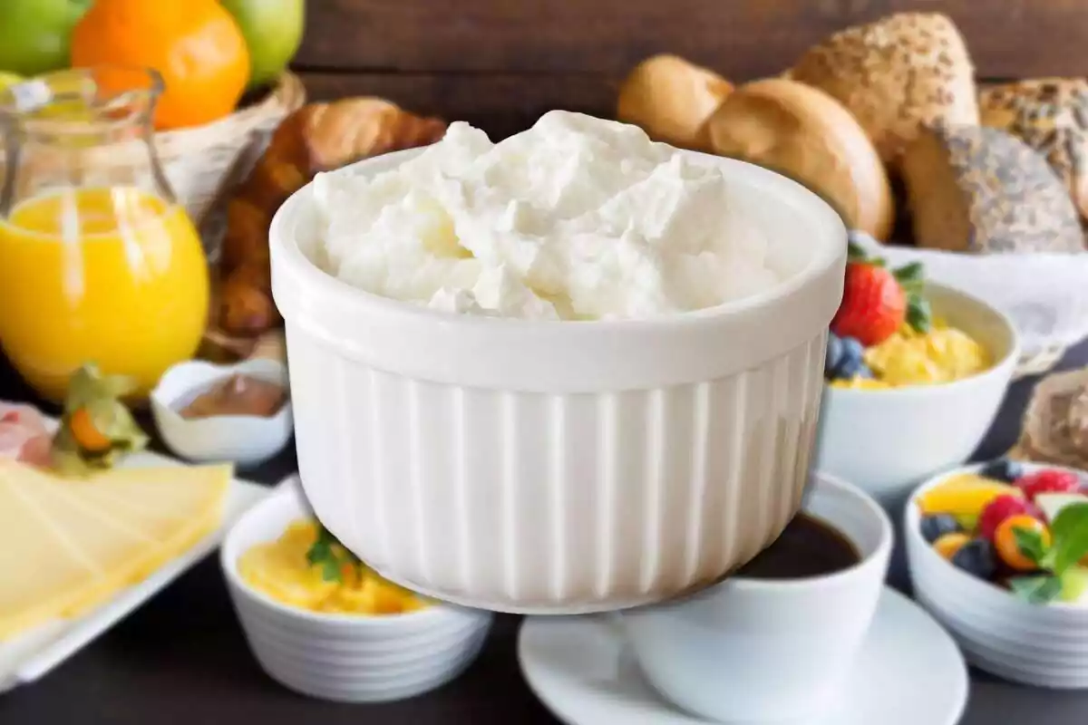 Muntatge amb una taula amb aliments d'esmorzar de fons i un bol amb mató al centre