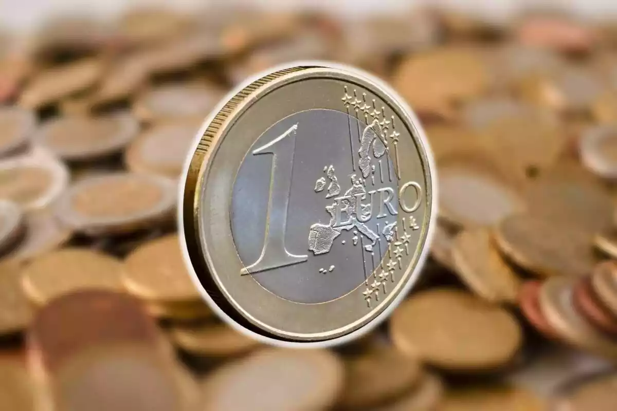 Muntatge amb diverses monedes de fons i una moneda d'un euro al centre