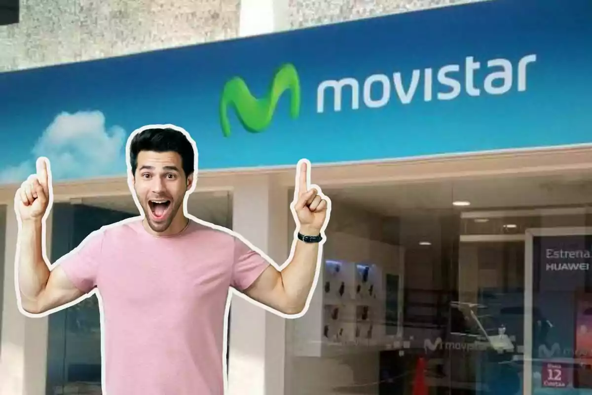 Un home amb samarreta rosa i expressió de sorpresa assenyala cap amunt amb tots dos dits davant una botiga de Movistar.