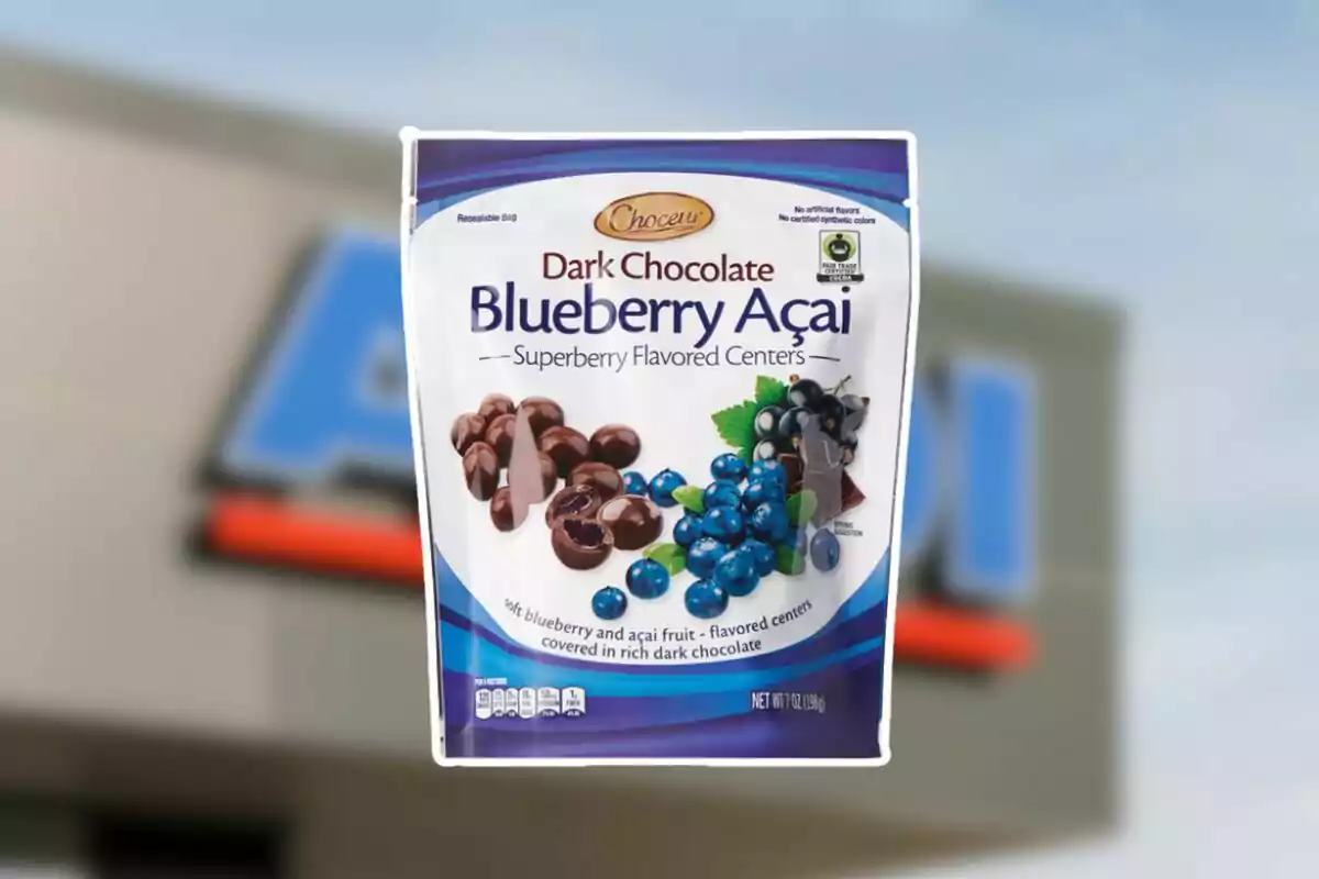 Bolsa de chocolates oscuros rellenos de arándano y açaí de la marca Choceur sostenida frente a una tienda Bolsa de chocolates oscuros rellenos de arándano y açaí de la marca Choceur sostenida frente a una tienda