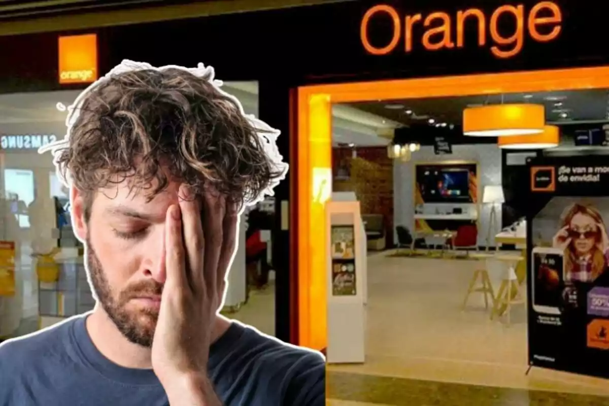 Un home amb expressió de frustració es cobreix la cara amb una mà davant una botiga de la companyia Orange.