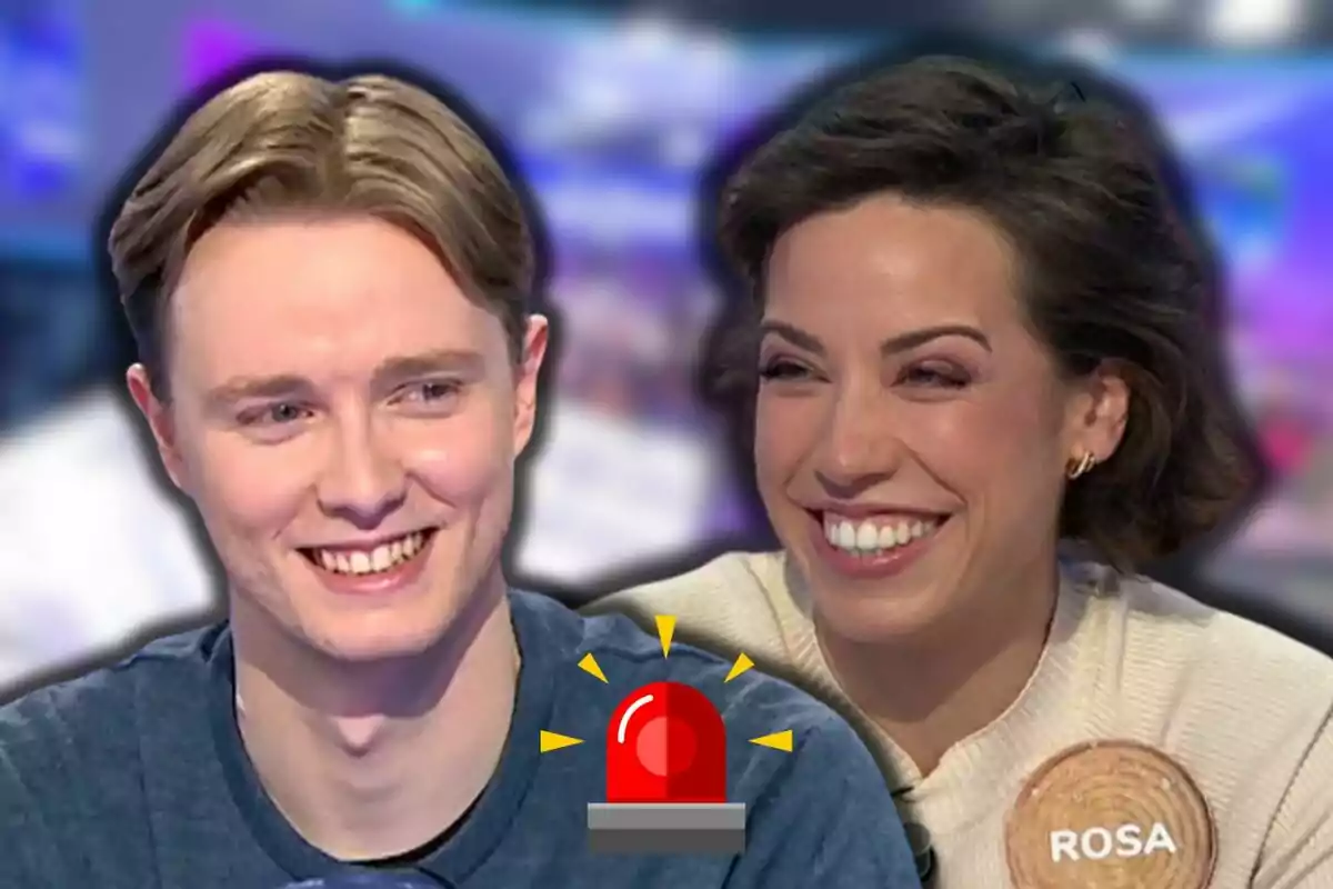 Manu i Rosa somrients en un programa de televisió amb una icona d'alarma vermella al centre.