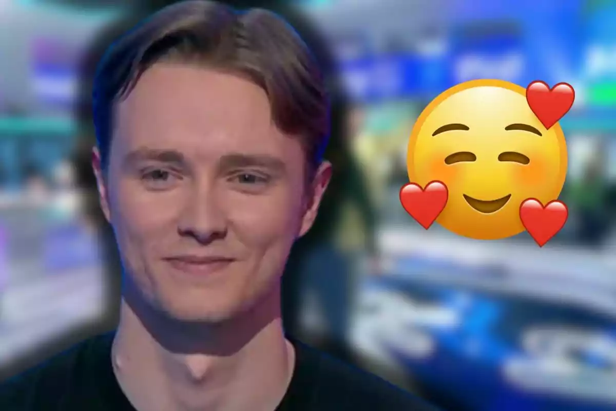 Manu somrient amb un fons desenfocat i un emoji de carona feliç amb cors al costat