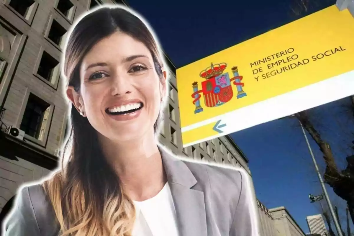 Una dona somrient davant d?un edifici amb un cartell del Ministeri d?Ocupació i Seguretat Social d?Espanya.