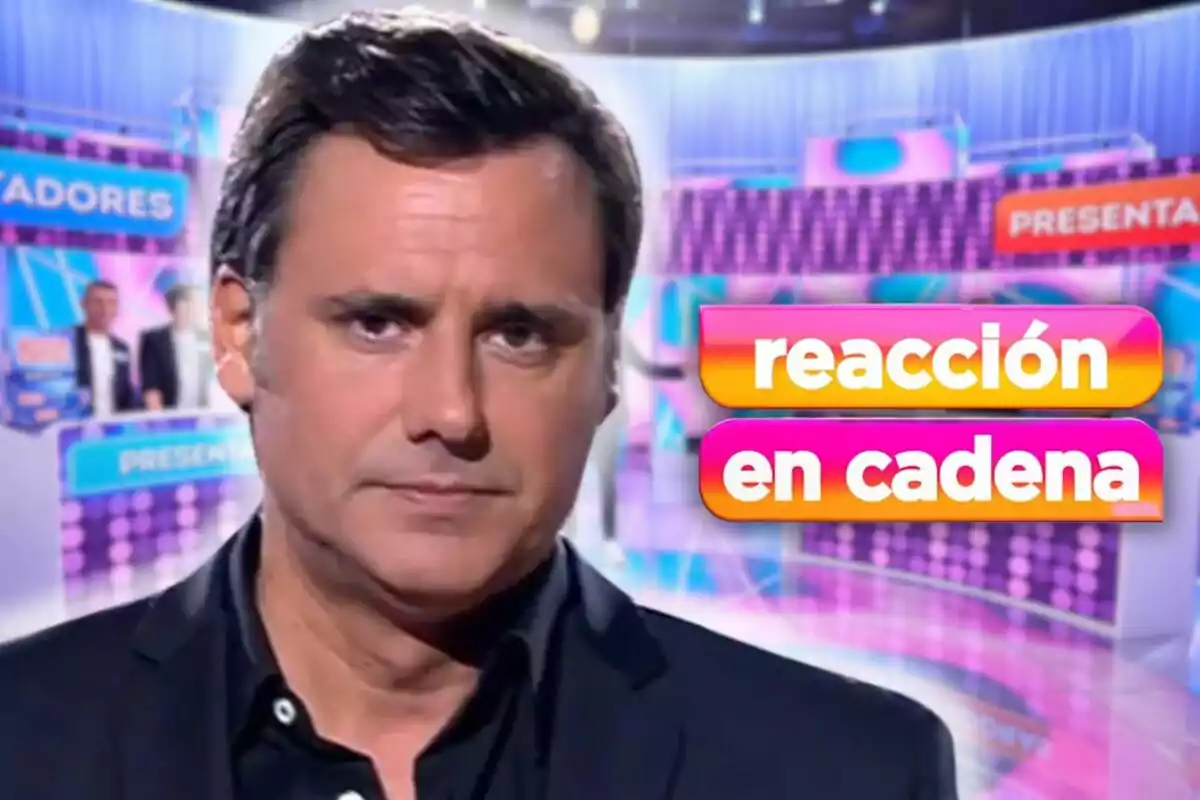 Ion Aramendi de cabell fosc en un set de televisió amb el text "reacció en cadena" en colors brillants.