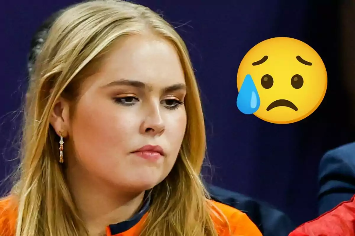 Amalia d’Holanda amb expressió seriosa i un emoji de carona trista amb una llàgrima al costat