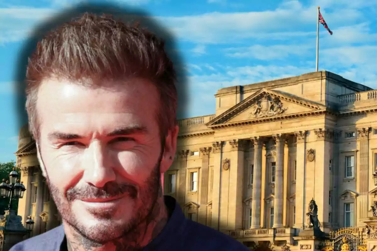David Beckham somrient amb barba davant d’un edifici històric amb una bandera britànica onejant a la part superior