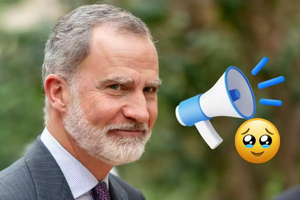 Felip VI amb vestit somriu lleument mentre apareixen un megàfon i un emoji de carona amb ulls brillants al seu costat
