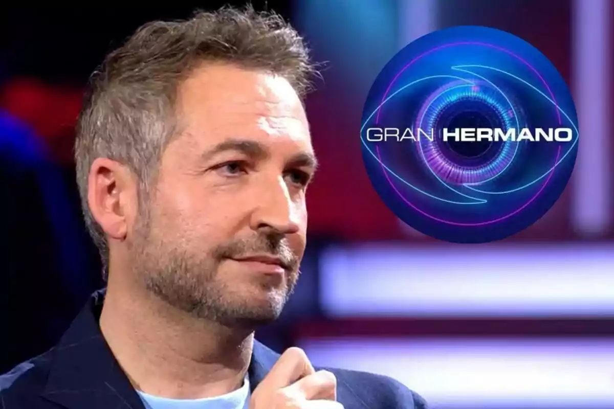 Fran Blanco amb barba i cabell curt en un estudi de televisió amb el logotip de Gran Hermano al fons.