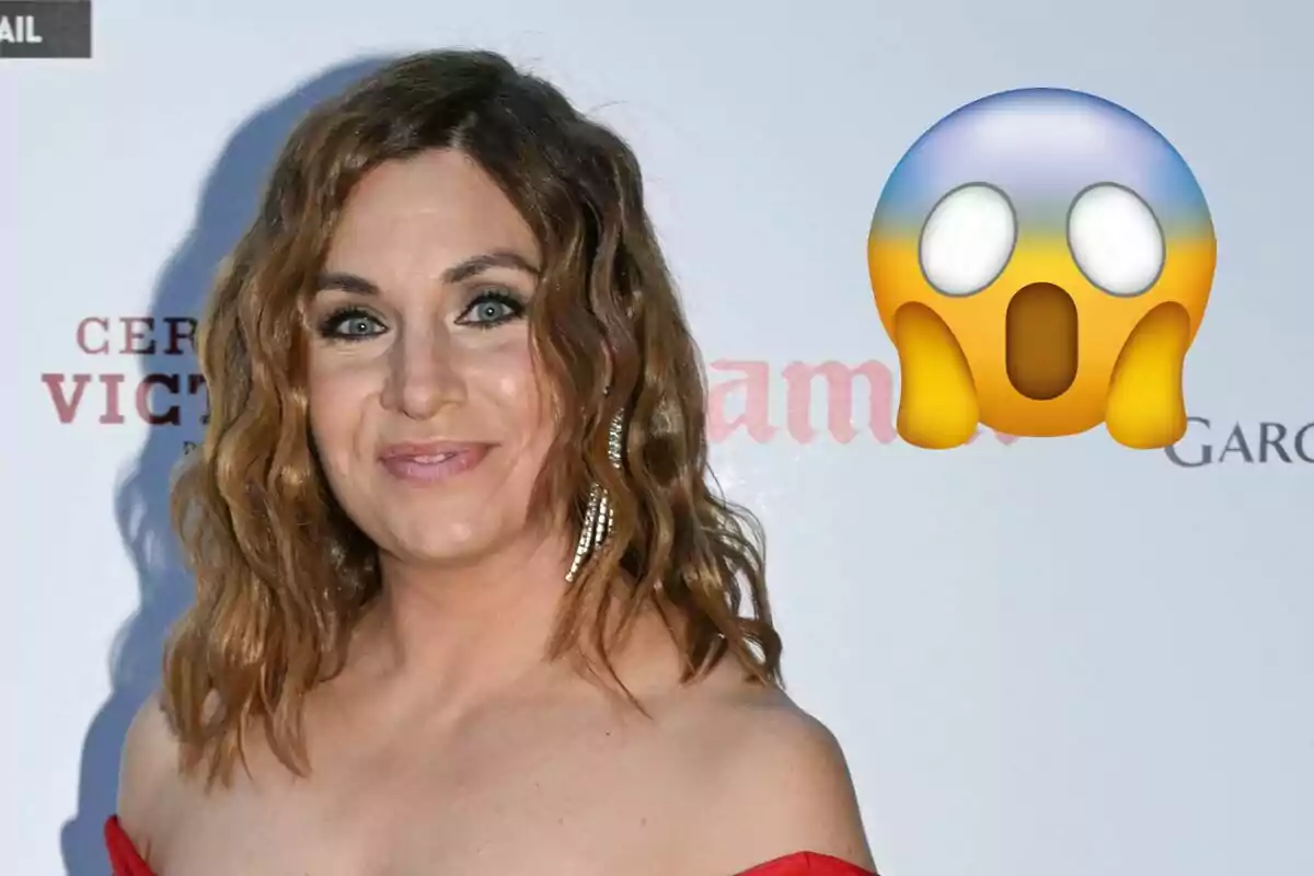 Leire Martínez amb cabell arrissat i un vestit vermell posant davant un fons amb text i un emoji de sorpresa al costat.