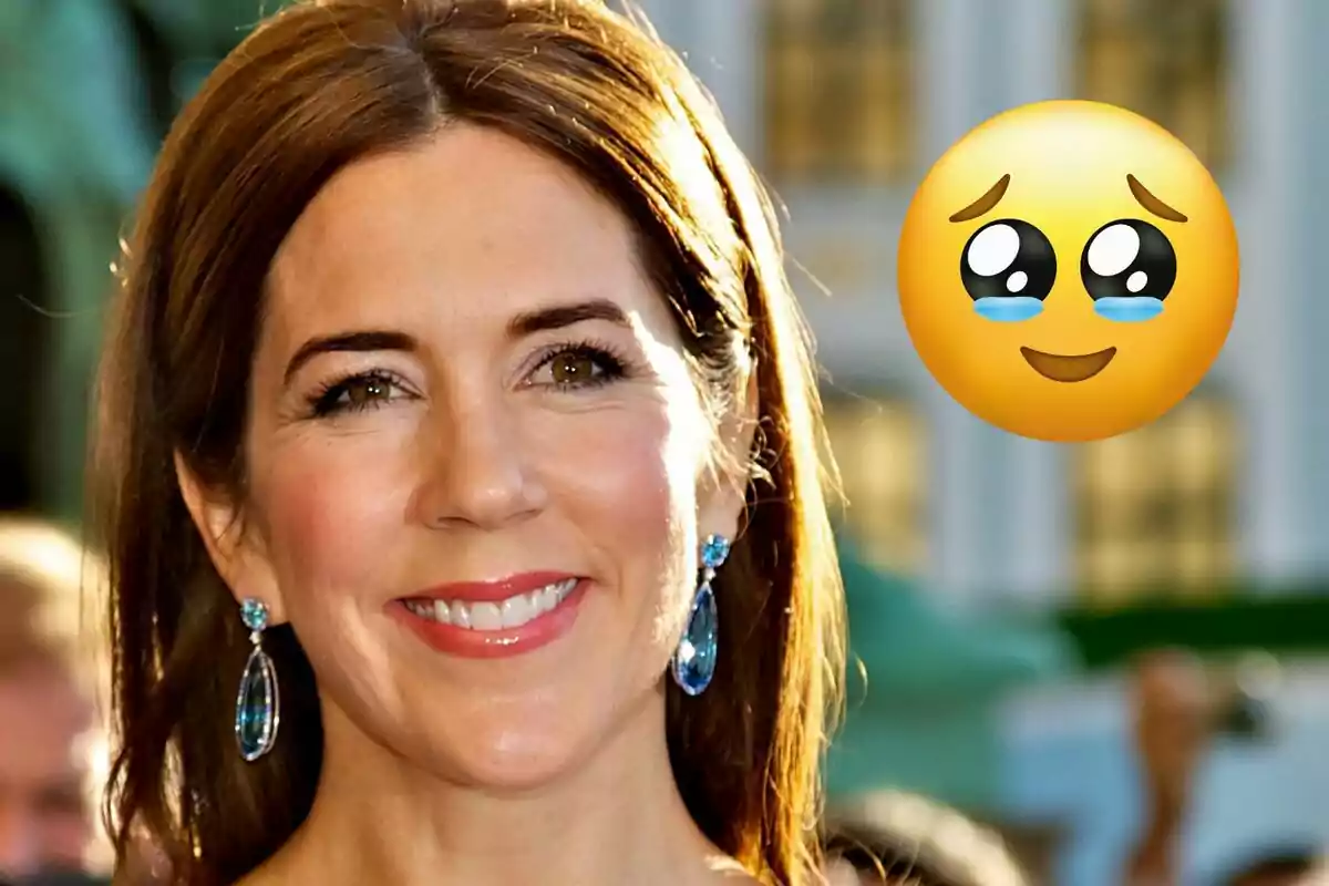 Mary de Dinamarca somrient amb arracades blaves i un emoji emocionat al costat.