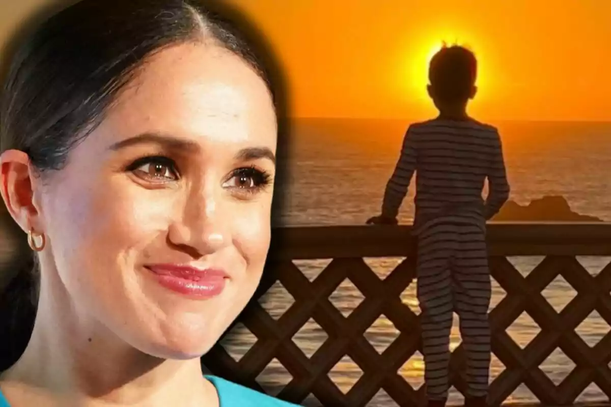 Primer plano de Meghan Markle sonriendo y al fondo Archie de espaldas mirando el atardecer sobre el mar