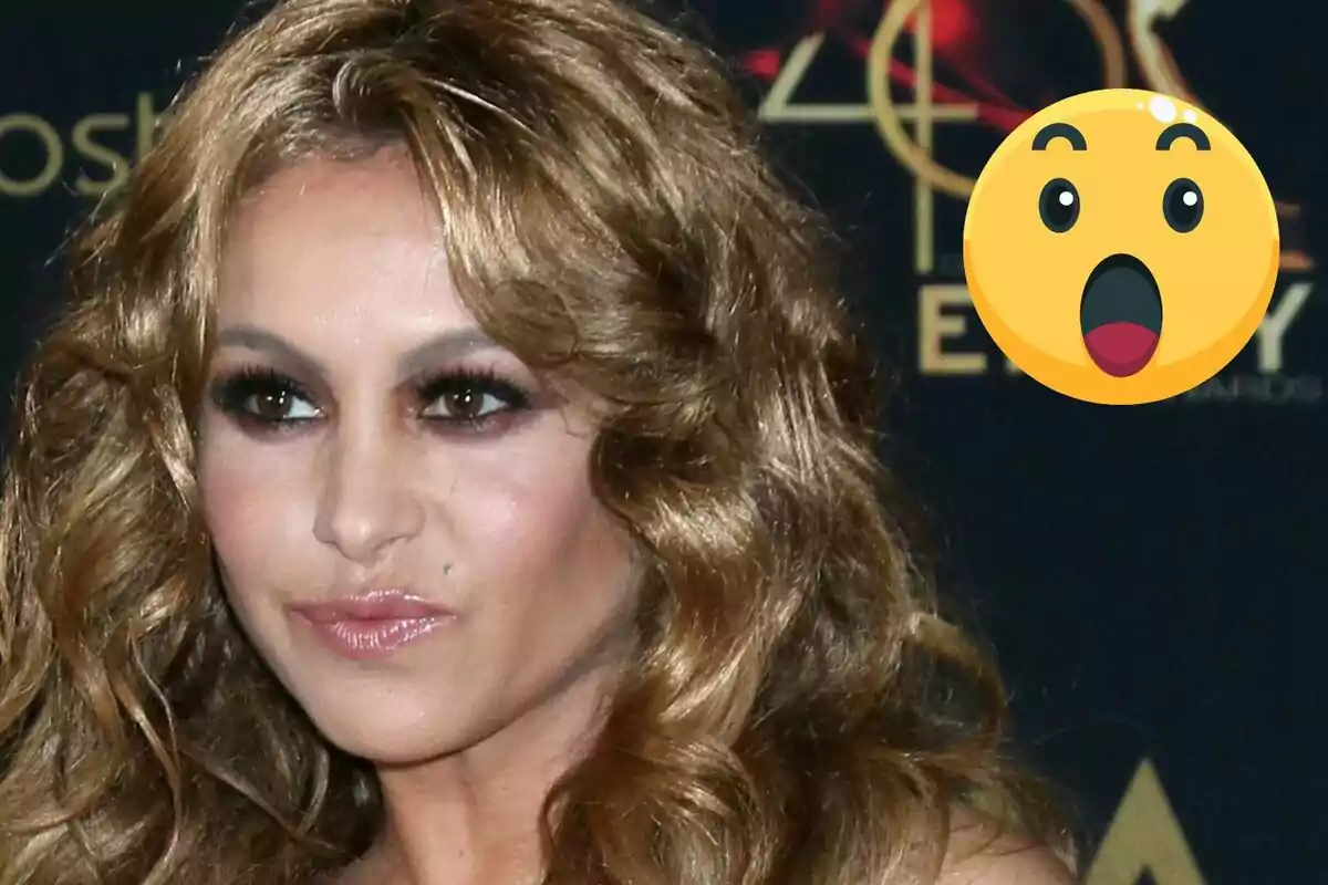 Paulina Rubio con expresión seria y un emoji de sorpresa en la esquina superior derecha