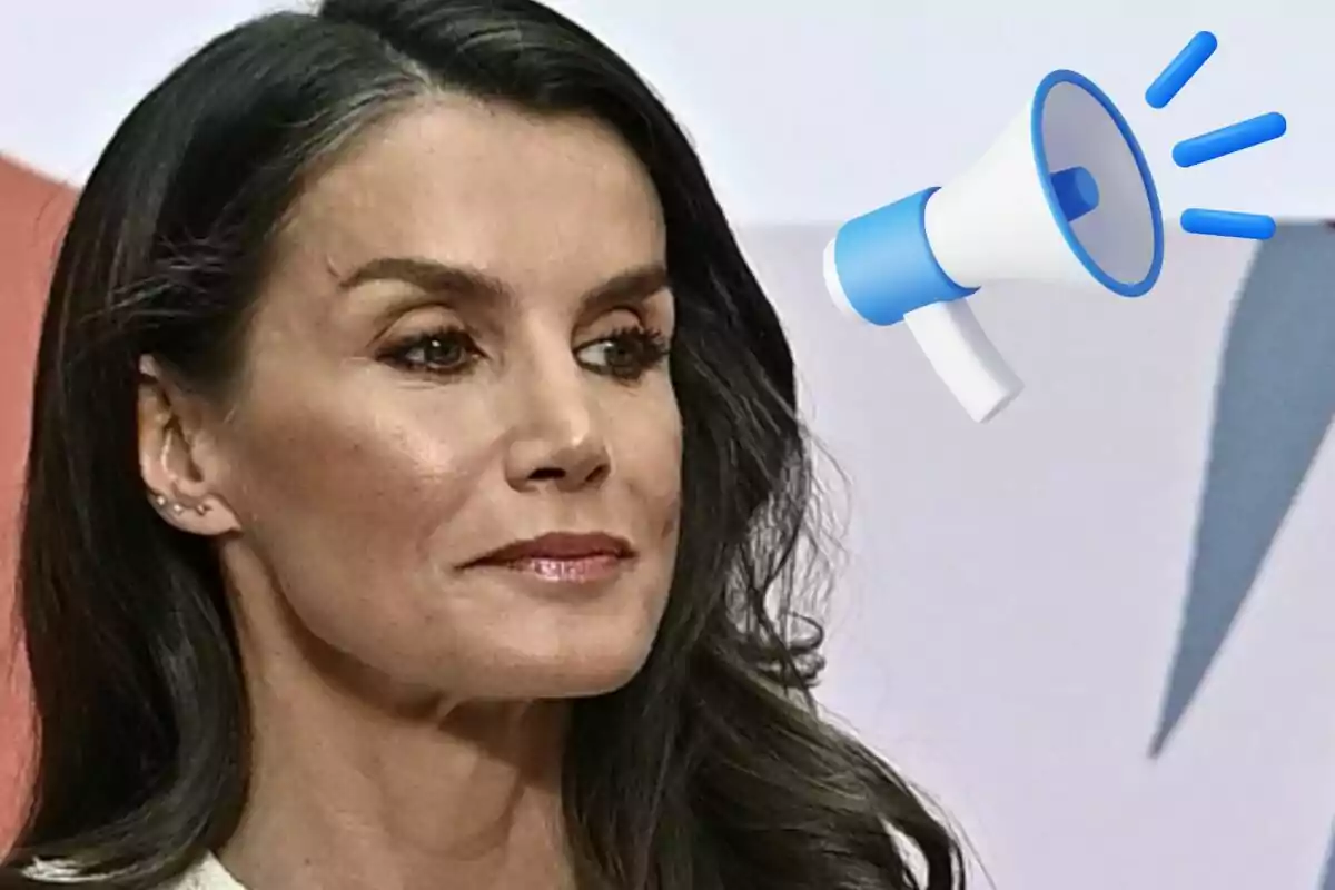 La reina Letícia amb un megàfon blau i blanc al fons.