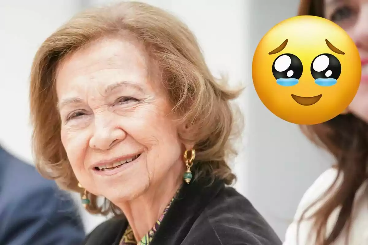 La reina Sofia somriu mentre un emoji amb ulls plorosos està superposat a la imatge.