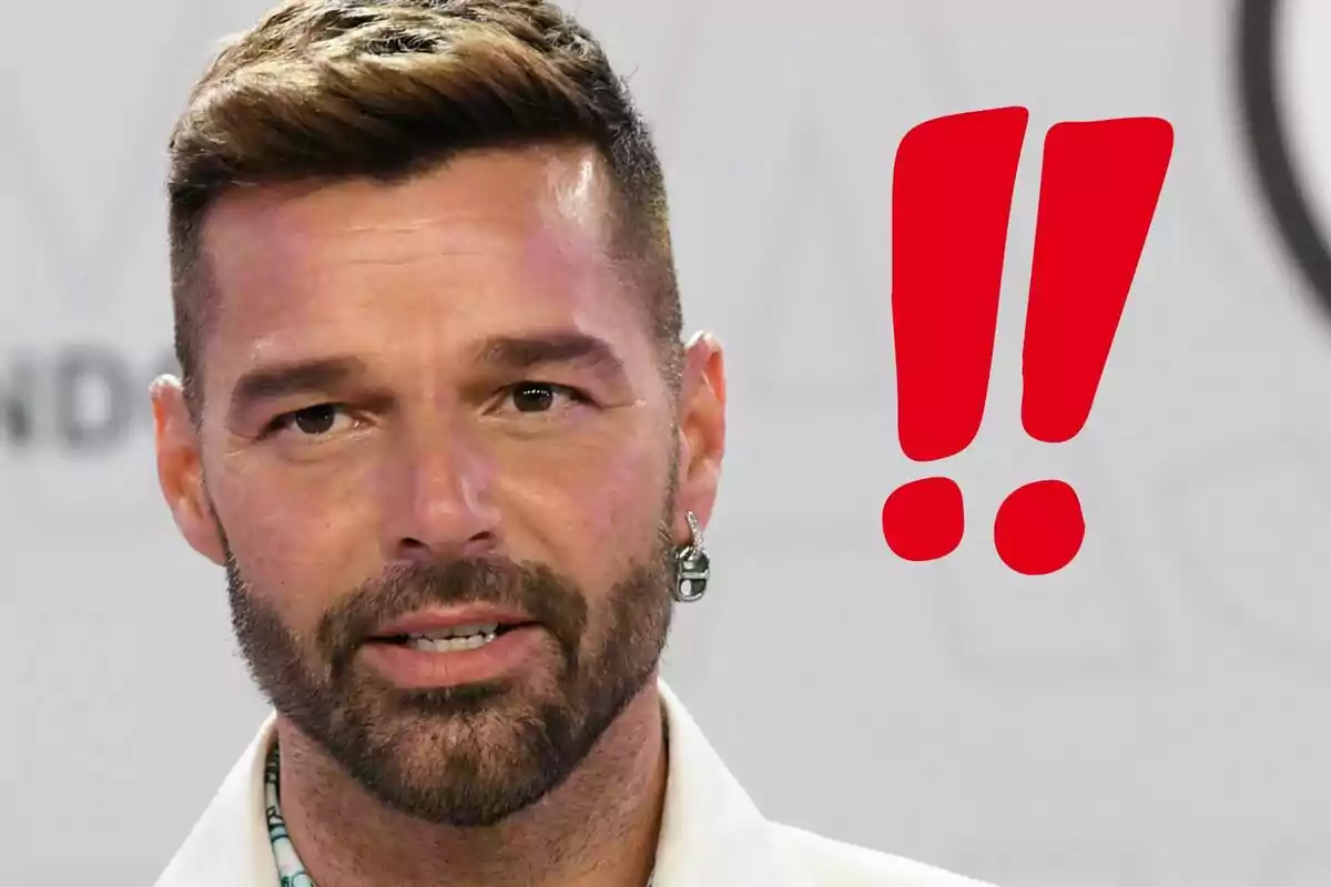 Ricky Martin looking straight ahead with two red exclamation marks in the background