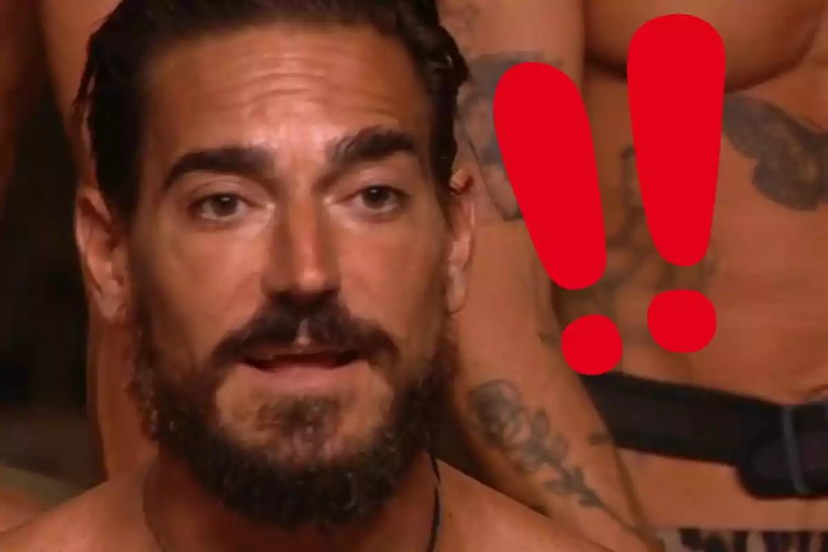 Damián Quintero amb expressió seriosa i dos signes d’exclamació vermells grans al fons