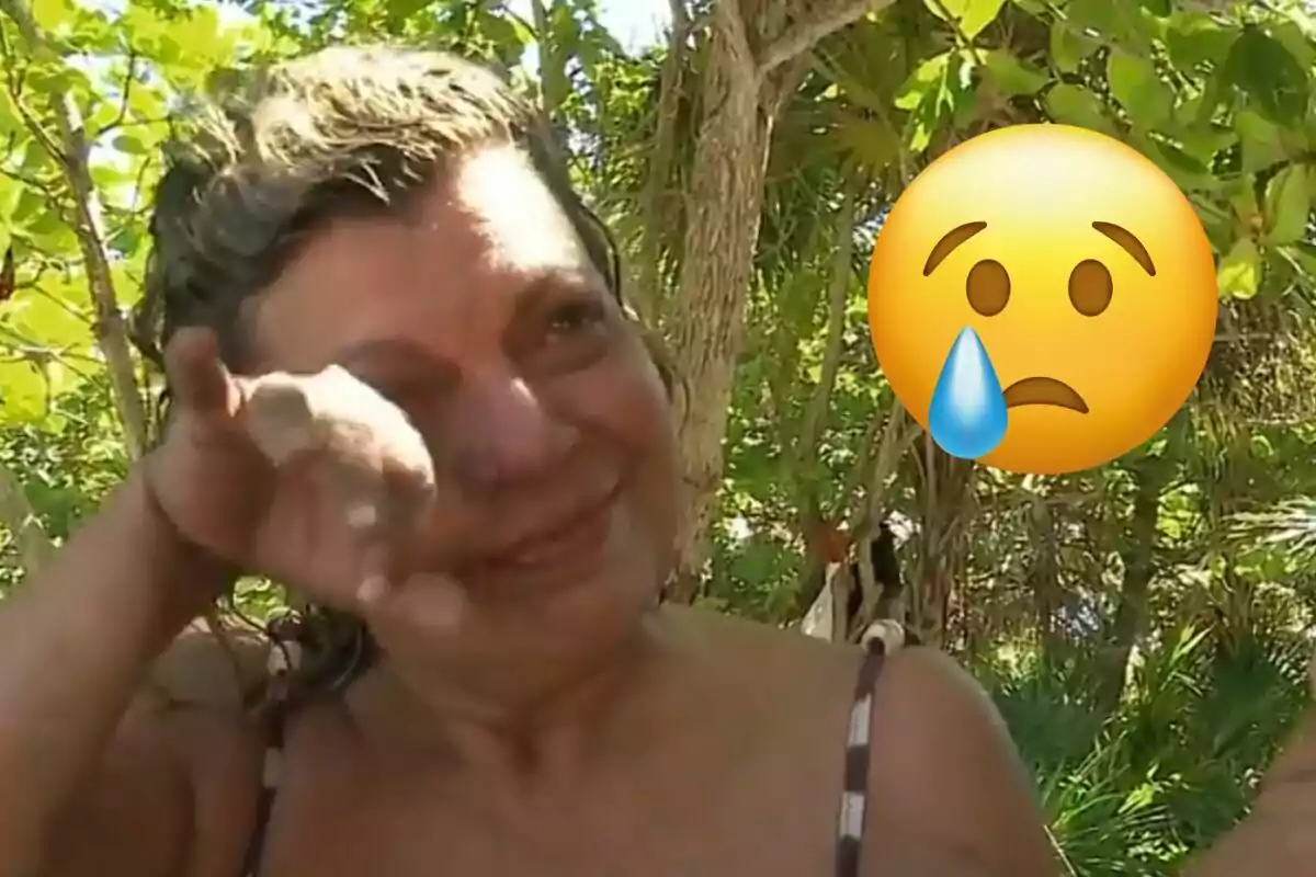 Terelu Campos s'eixuga les llàgrimes en un entorn natural amb un emoji de cara trista al costat.