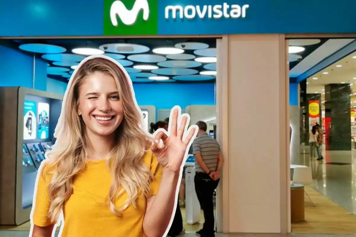 Una dona somrient amb samarreta groga fa un gest de “ok” davant d'una botiga de Movistar.