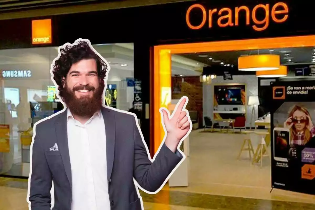 Un home somrient amb barba i vestit assenyala cap a una botiga d'Orange.