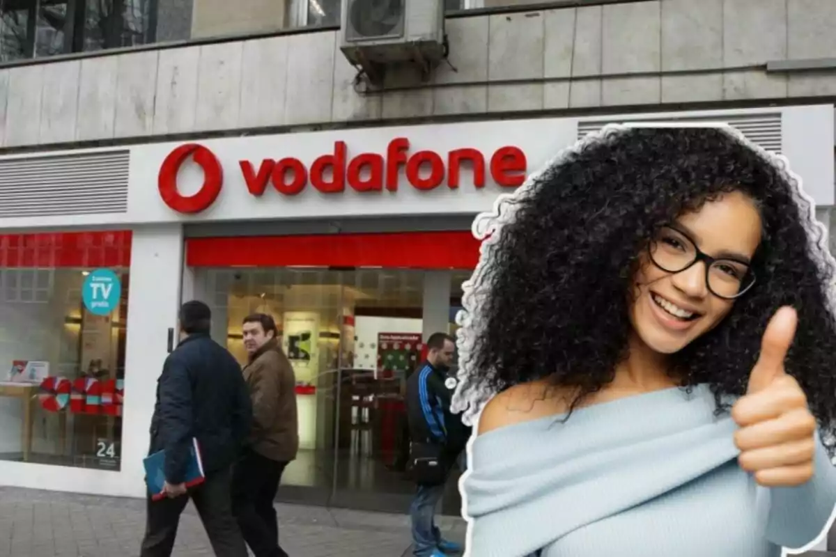 Una botiga de Vodafone ia la dreta una noia amb el polze enlaire