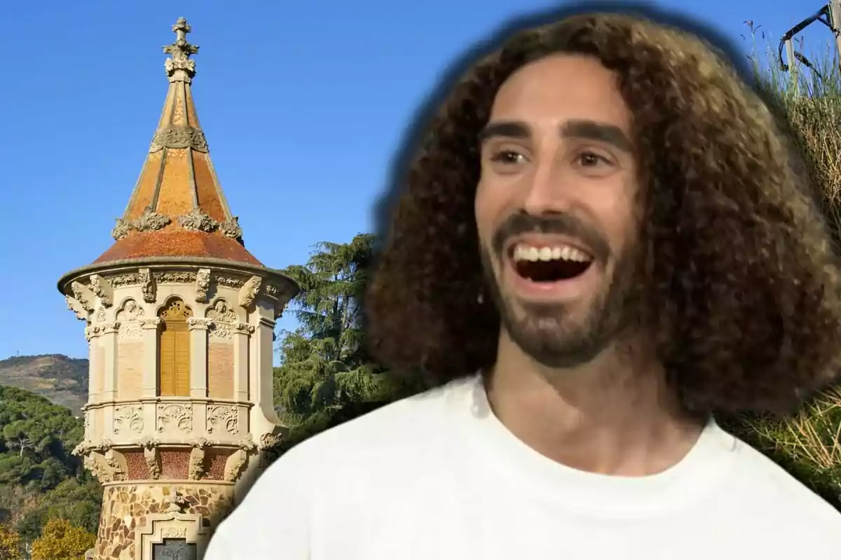 Marc Cucurella sonriendo frente a una torre antigua con cielo azul de fondo