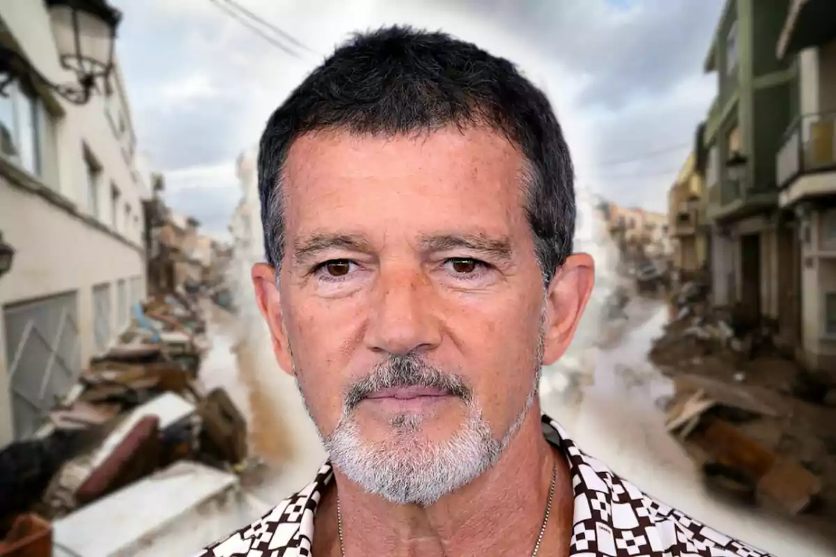 Antonio Banderas de cabell fosc i barba canosa està davant d'un fons d'un carrer amb runes i edificis danyats.