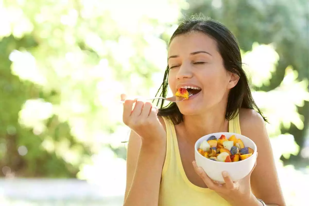 Dona menjant un bol ple de fruita