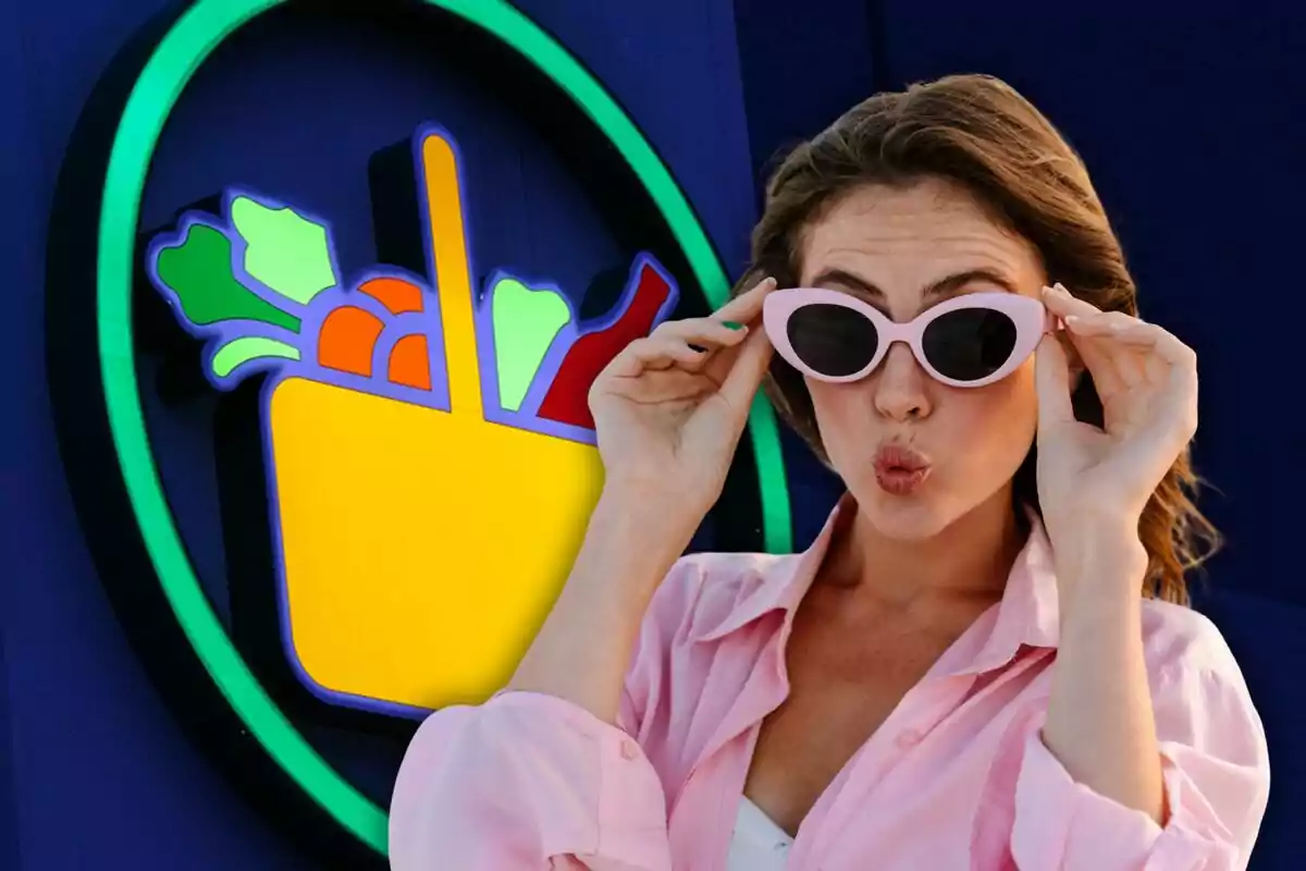 Una dona amb ulleres de sol roses fa un gest divertit davant d'un cartell de supermercat acolorit.
