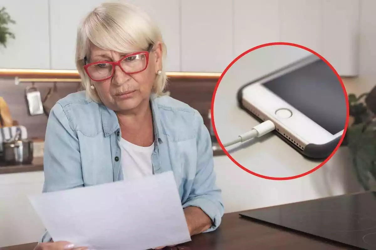 Elderly woman looking at electricity bill and mobile phone plugged into charger