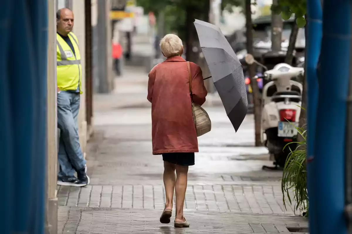 Una dona passeja per un carrer amb un paraigua, el 21 de maig de 2023, a Madrid.