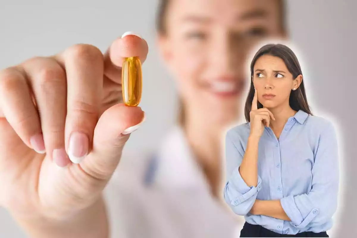 Dona preocupada mirant una pastilla de vitamina