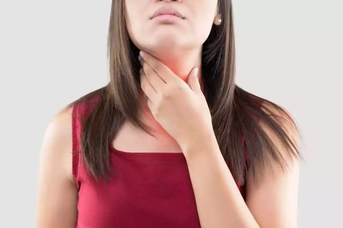 Woman touching her throat region because of pain Woman touching her throat region because of pain
