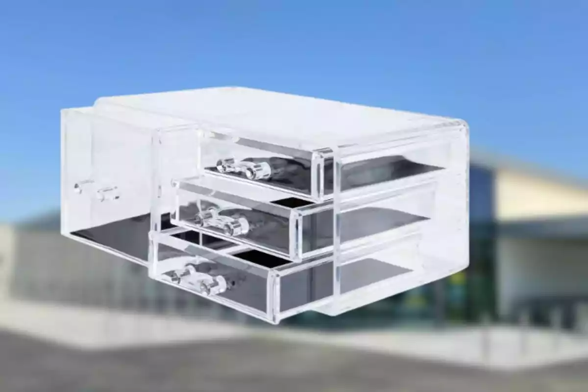 Calaixera d'acrílic transparent amb tres compartiments sobre un fons desenfocat. Calaixera d'acrílic transparent amb tres compartiments sobre un fons desenfocat.
