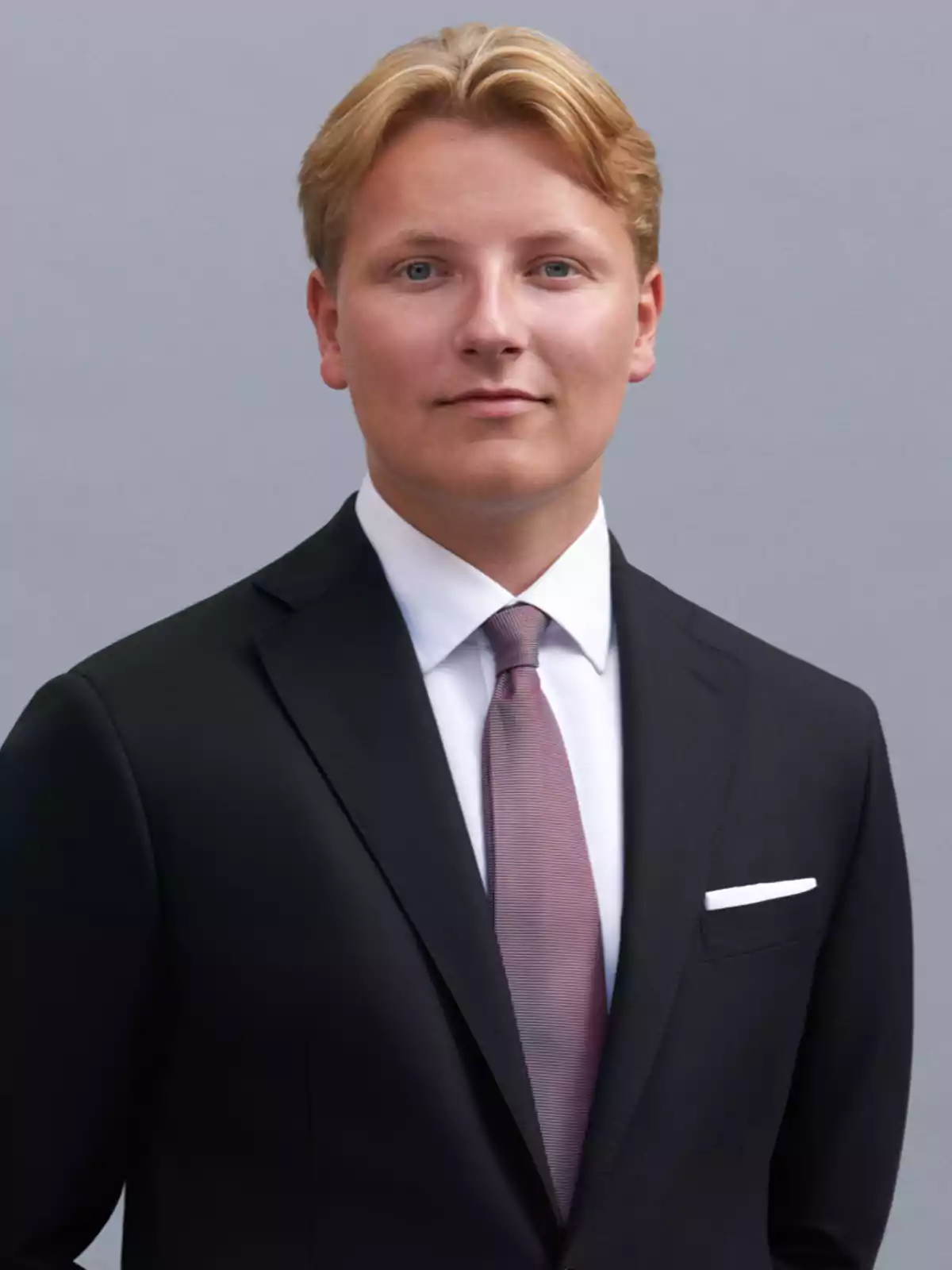 Sverre de Noruega con traje oscuro posando frente a un fondo gris. Sverre de Noruega con traje oscuro posando frente a un fondo gris.