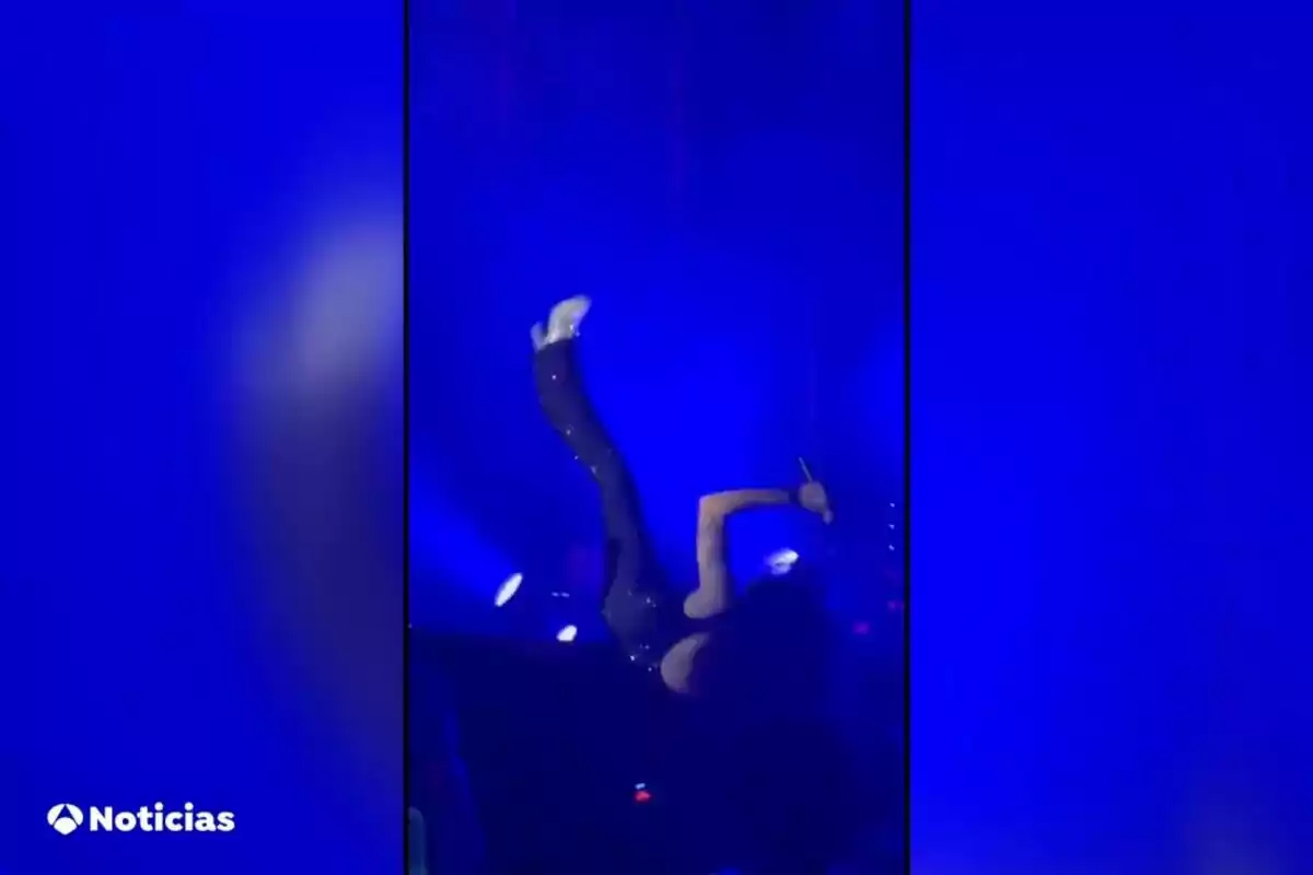 Mario Vaquerizo en el escenario realiza una acrobacia con un fondo iluminado en azul.