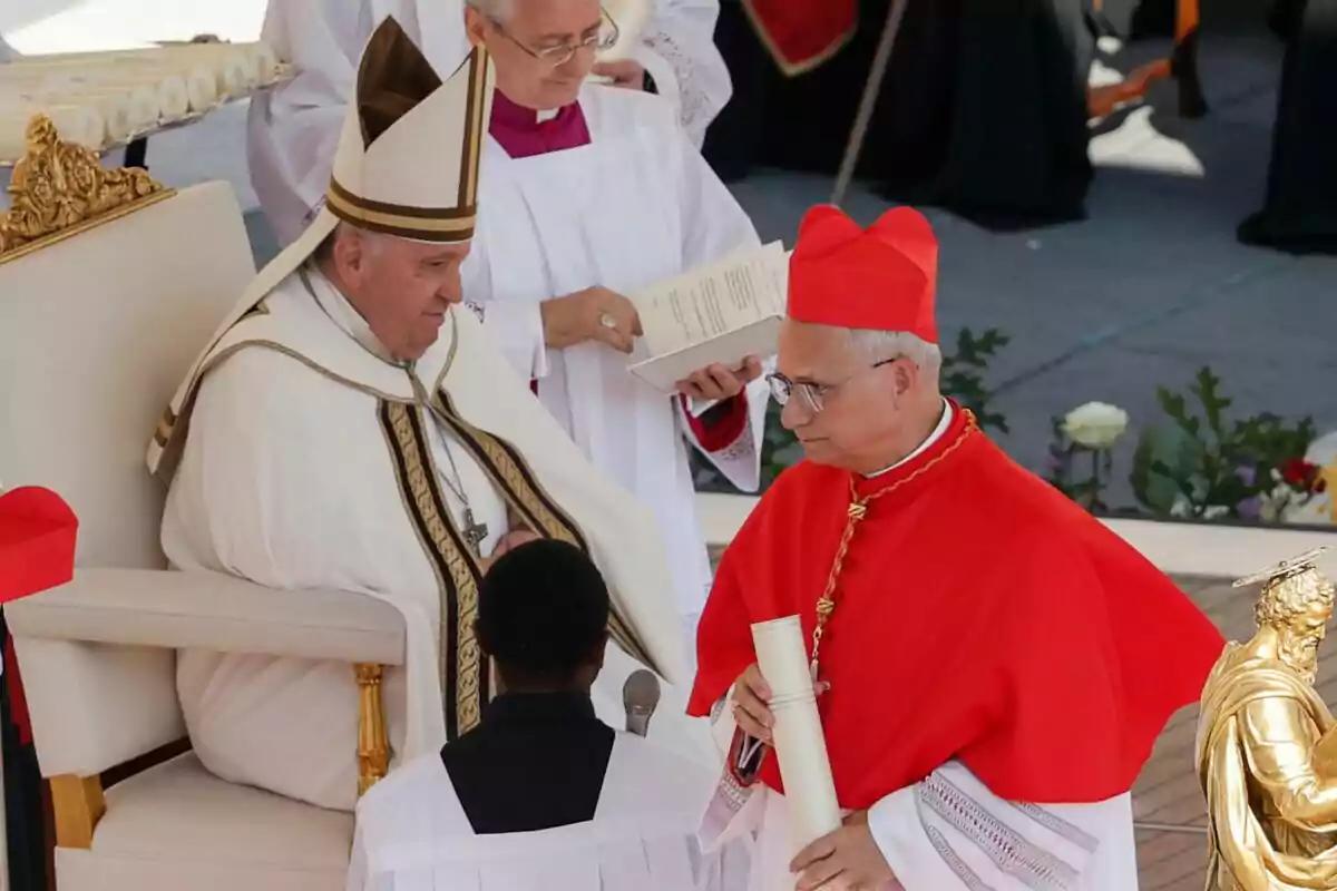 A religious leader seated at a ceremony while interacting with a cardinal holding a document, accompanied by assistants in liturgical attire. A religious leader seated at a ceremony while interacting with a cardinal holding a document, accompanied by assistants in liturgical attire.