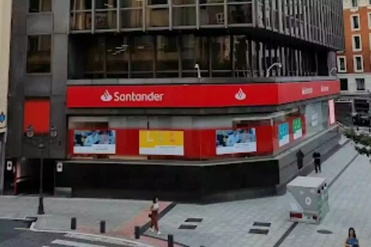 Façana d'una sucursal del banc Santander a una cantonada d'un carrer urbà.